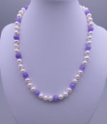 A 14 ct gold pearl and lilac jade necklace. Approximately 42 cm long.