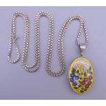 A German silver painted locket on a silver chain. The locket 2.5 cm wide.