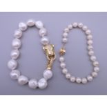 A pearl bracelet with a 14 K gold clasp and a pearl bracelet with a panther formed clasp.