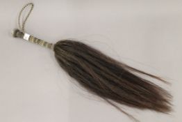 An antique Indian fly whisk with plaited hair handle and silver terminal. 66 cm long.