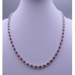 A 925 silver and rhodium plated synthetic ruby and diamond necklace. Approximately 40 cm long.