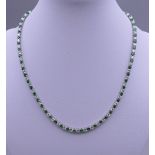 A 925 silver and rhodium plated synthetic emerald and diamond necklace. 40.5 cm long.