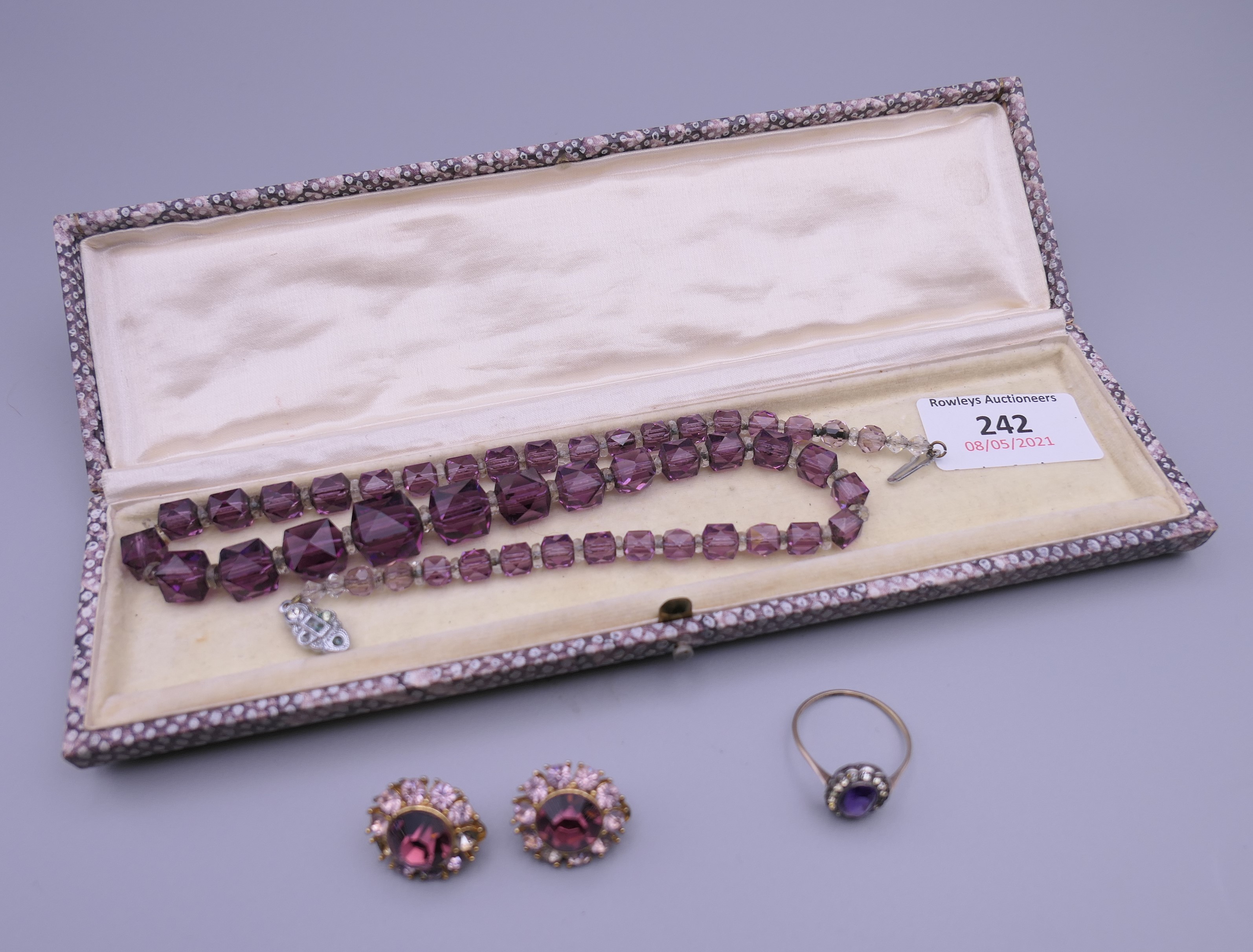 An amethyst set gold ring, together with a dress necklace and a pair of clip on earrings.