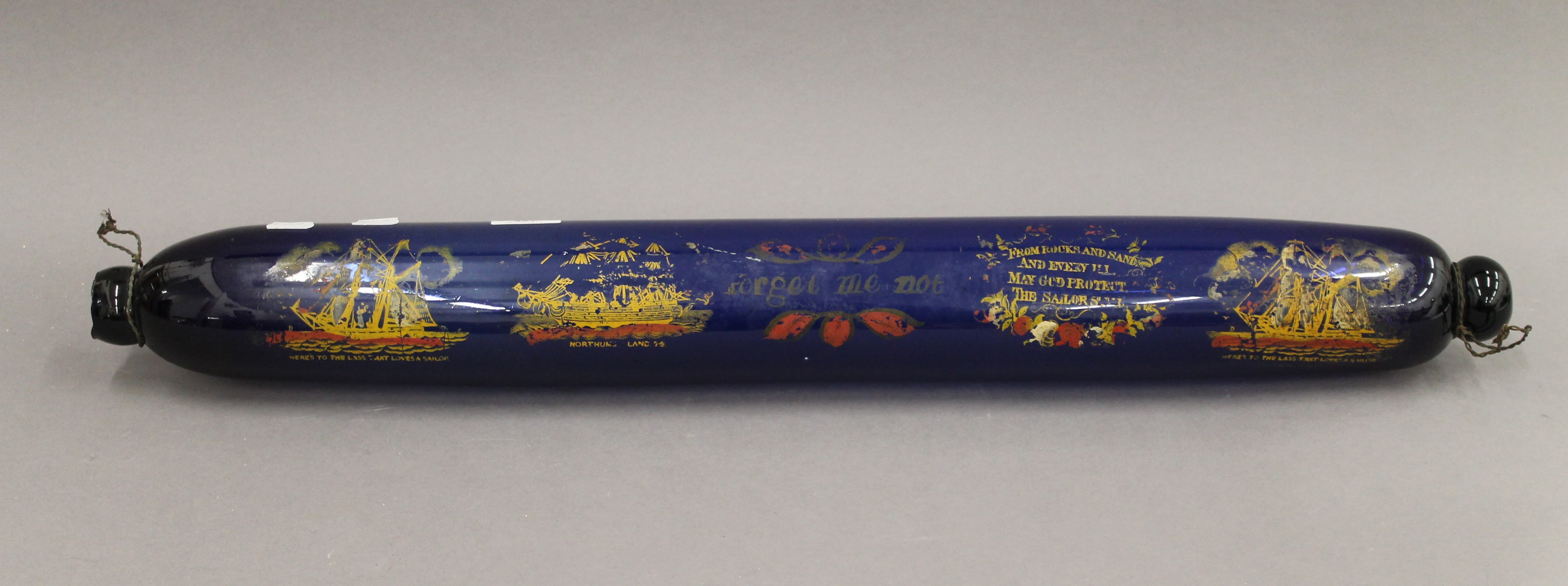 A large Victorian blue glass rolling pin, painted with various ships and verses. 77 cm long.