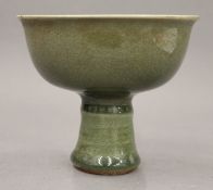 A Chinese celadon ground pottery stem cup. 11.5 cm high.