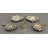 A pair of silver pierced dishes, a napkin ring and two strainers. The former 10 cm wide. 3.