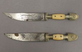 Two Eastern bone handled daggers, each with an engraved blade. The largest 23.5 cm long.