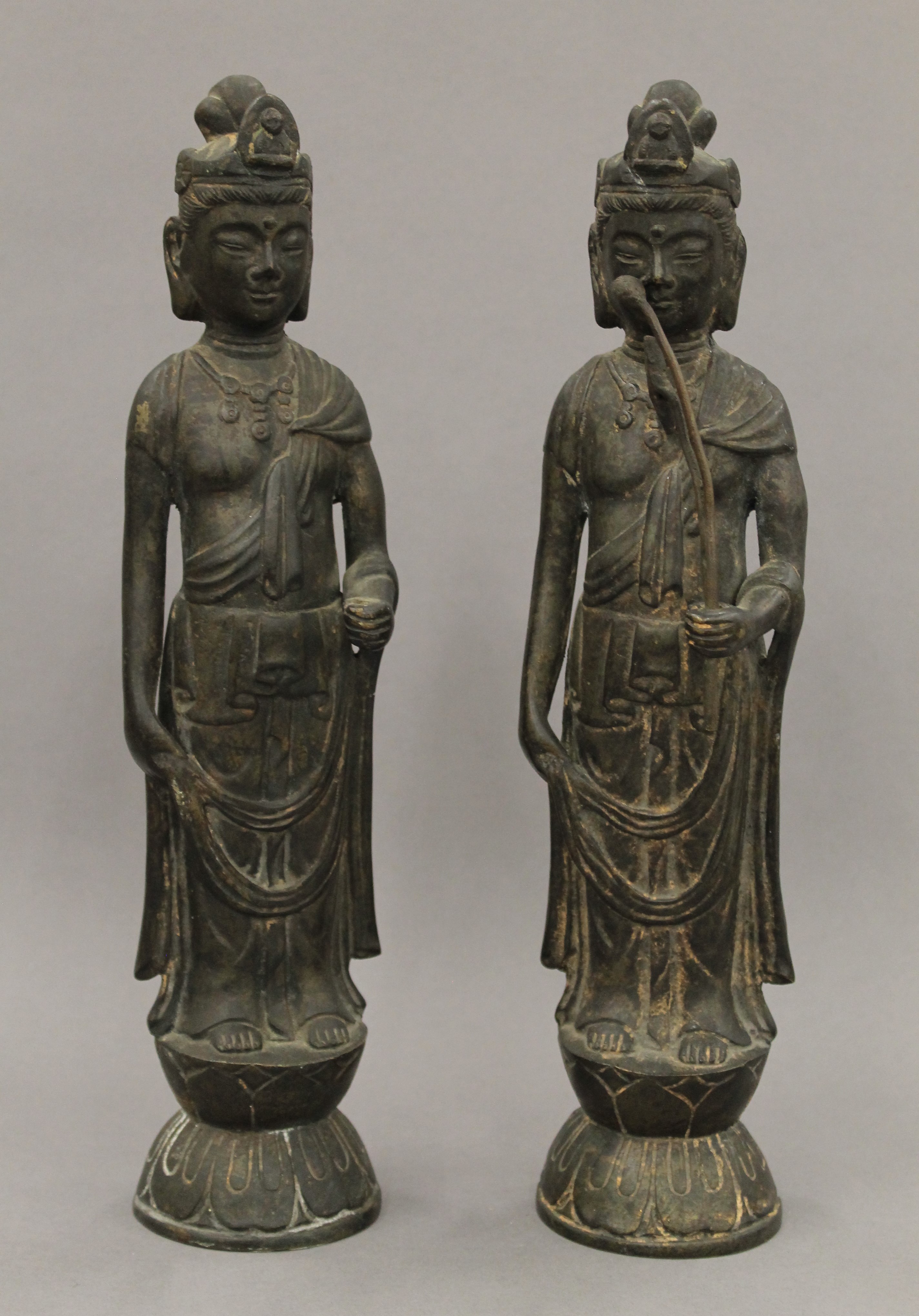 A pair of Chinese patinated bronze models of Guanyin. Each 32 cm high.