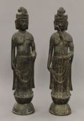 A pair of Chinese patinated bronze models of Guanyin. Each 32 cm high.