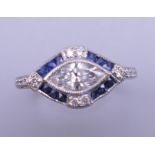 An Art Deco style platinum marquis cut diamond and sapphire ring. Ring size N/O. 4.