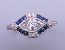 An Art Deco style platinum marquis cut diamond and sapphire ring. Ring size N/O. 4.