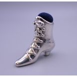 A silver pin cushion in the form of a boot. 4 cm high.