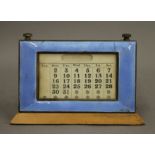 An enamel decorated silver desk calendar. 13 cm high.