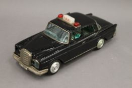 A Japanese tin plate Mercedes taxi, with opening doors and flashing top light. 25.5 cm long.