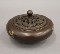 A Chinese bronze pierced top gold splash censer. 10 cm diameter.