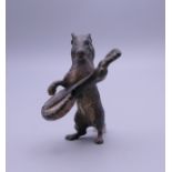 A cold painted bronze model of a dog playing a banjo. 4 cm high.