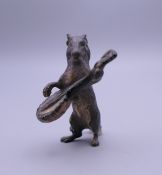 A cold painted bronze model of a dog playing a banjo. 4 cm high.