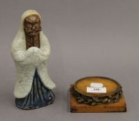 A 19th century Japanese pottery figure, possibly Bodhidharma, on an ormolu mounted plinth base. 22.