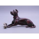 A cold painted bronze model of a dog and bone. 7 cm long.