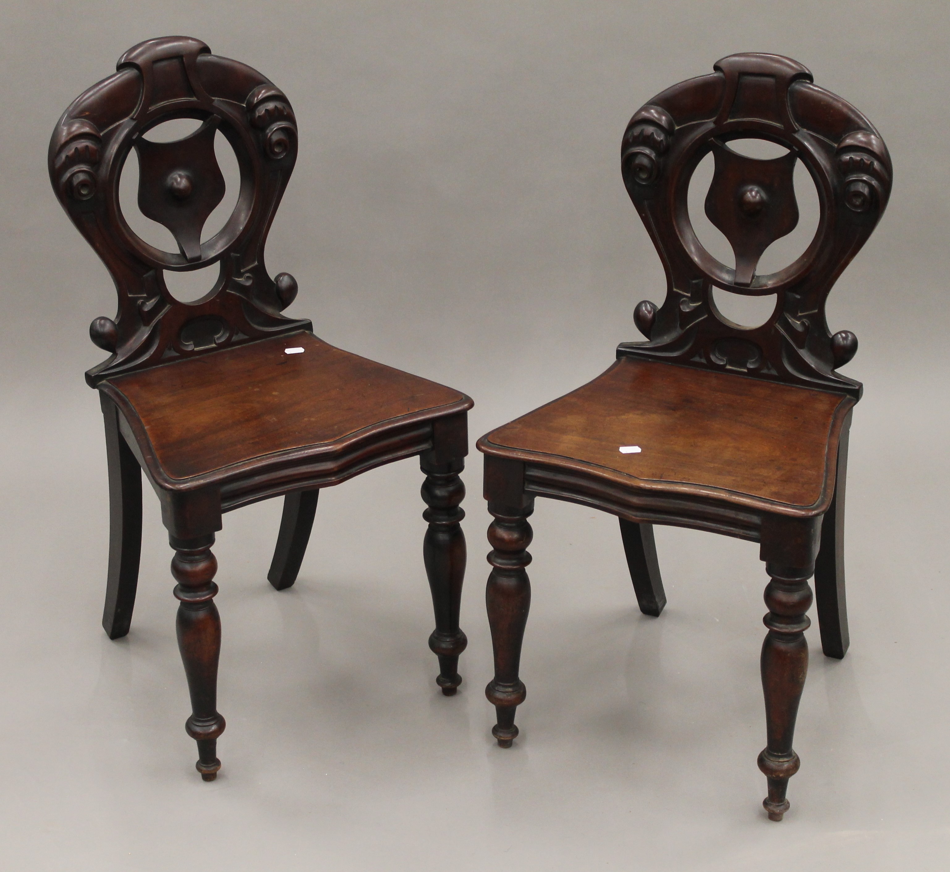 A pair of Victorian mahogany hall chairs. 43.5 cm wide.