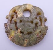 A carved jade roundel. 5.5 cm wide.