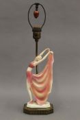 A table lamp mounted with a porcelain Art Deco dancing lady. 55.5 cm high overall.