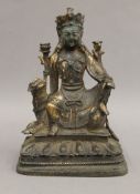 An 18th century Chinese bronze model of a deity sitting astride a dog-of-fo. 21.5 cm high.