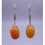 A pair of antique butterscotch amber earrings. Approximately 12.9 grammes total weight.