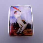 A silver pill box depicting a cricketer. 2.5 cm wide.