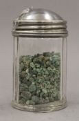 A jar of loose uncut emeralds.