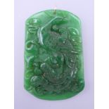 A gold mounted carved apple green jade pendant. 6.5 cm high.