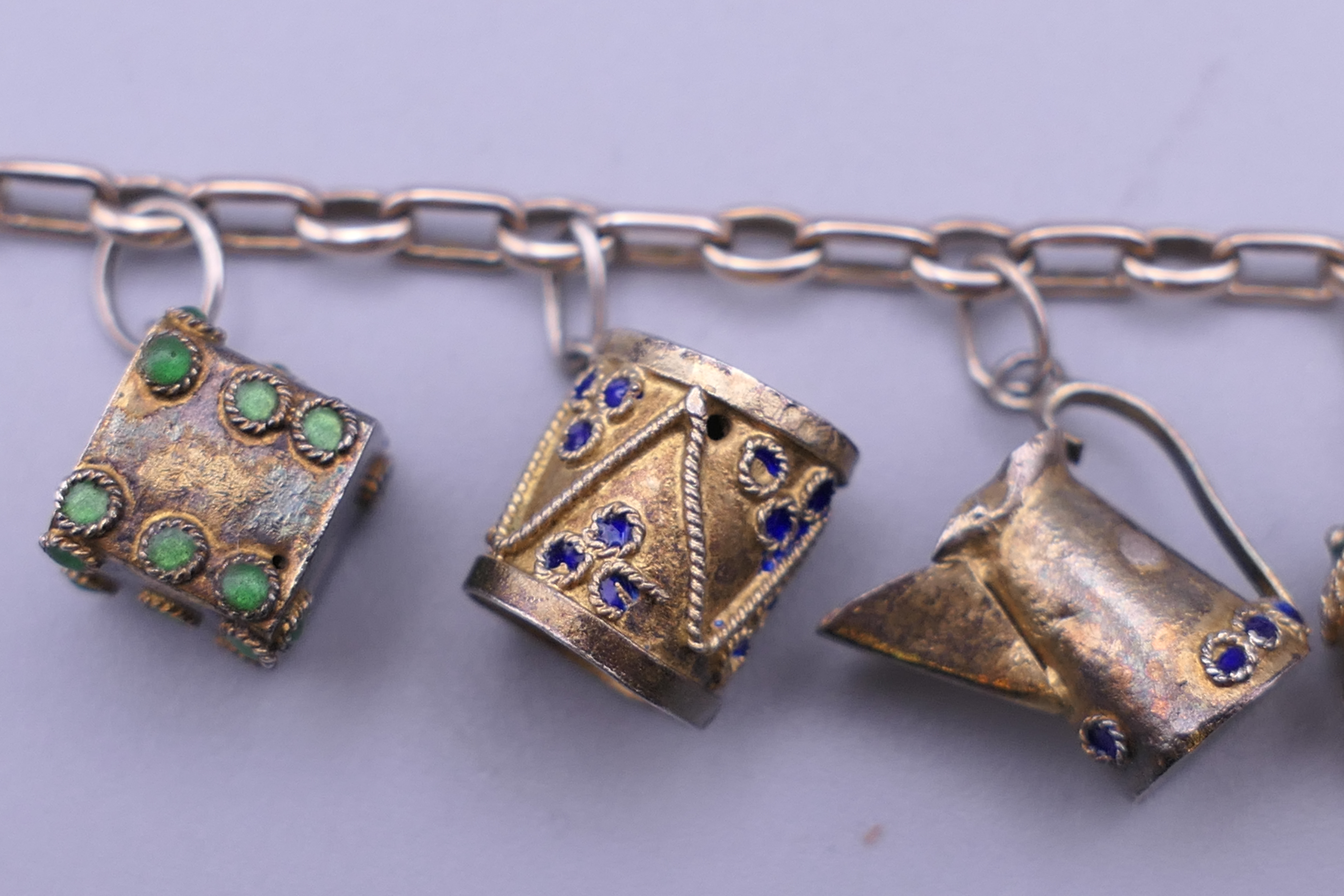 A unmarked gold bracelet with twelve silver gilt and enamelled charms. Approximately 18 cm long. - Image 2 of 6