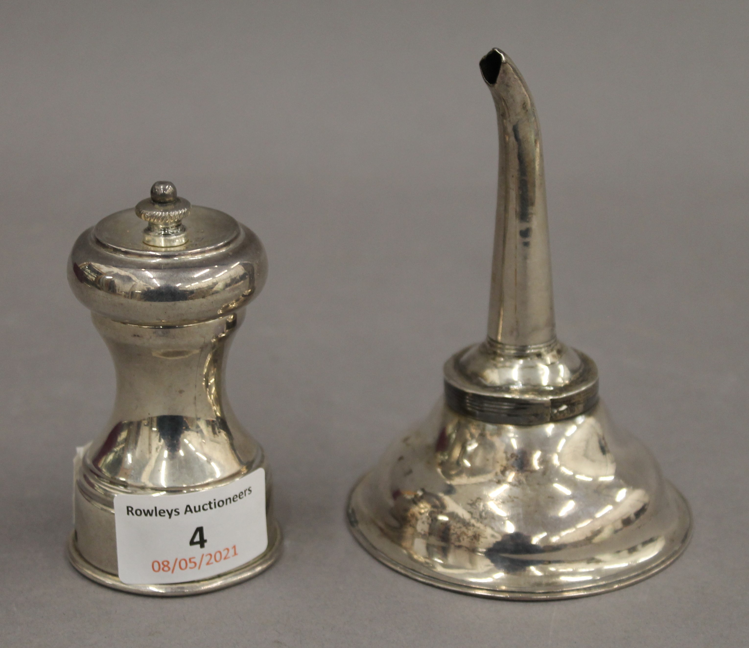 A silver wine funnel and a silver pepper grinder. The former 11.5 cm high. 6.