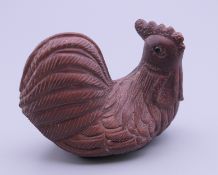 A Japanese wooden netsuke formed as a chicken. 5 cm long.