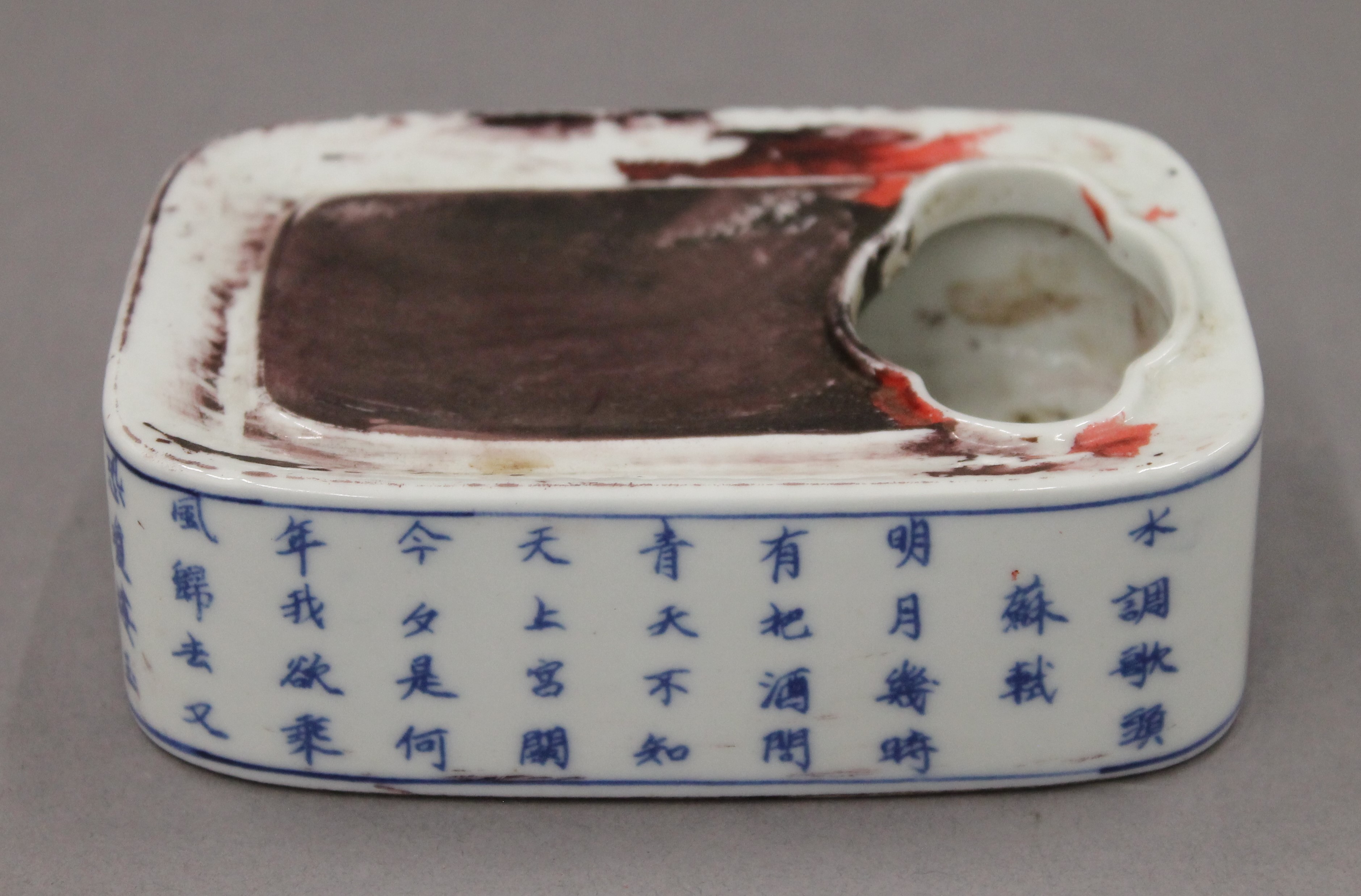 A Chinese blue and white porcelain inkstone decorated with calligraphy. 13 cm long.