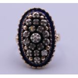 An antique gold diamond and blue enamel oval ring. Ring size M. 8.3 grammes total weight.