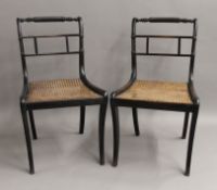 A pair of early 19th century ebonised mahogany rope back chairs (Nelson chairs), with cane seats.