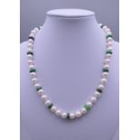 A pearl and jade necklace with a 14 ct gold clasp. Approximately 41 cm long.