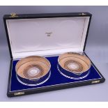 A cased pair of silver coasters. Each 12.5 cm diameter.