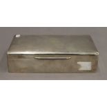 A silver cigarette box. 18 cm wide. 12.2 troy ounces total weight.