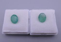 Two loose emeralds. Each approximately 9 mm long.