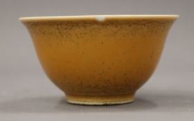 A Chinese orange ground porcelain tea bowl. 8.5 cm diameter.