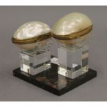 Two small shell boxes on a display base.
