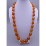 A butterscotch amber string of beads, 29 in total. Approximately 60 grammes.