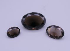 Three smokey quartz cut gemstones. The largest 3.5 x 2.5 cm.
