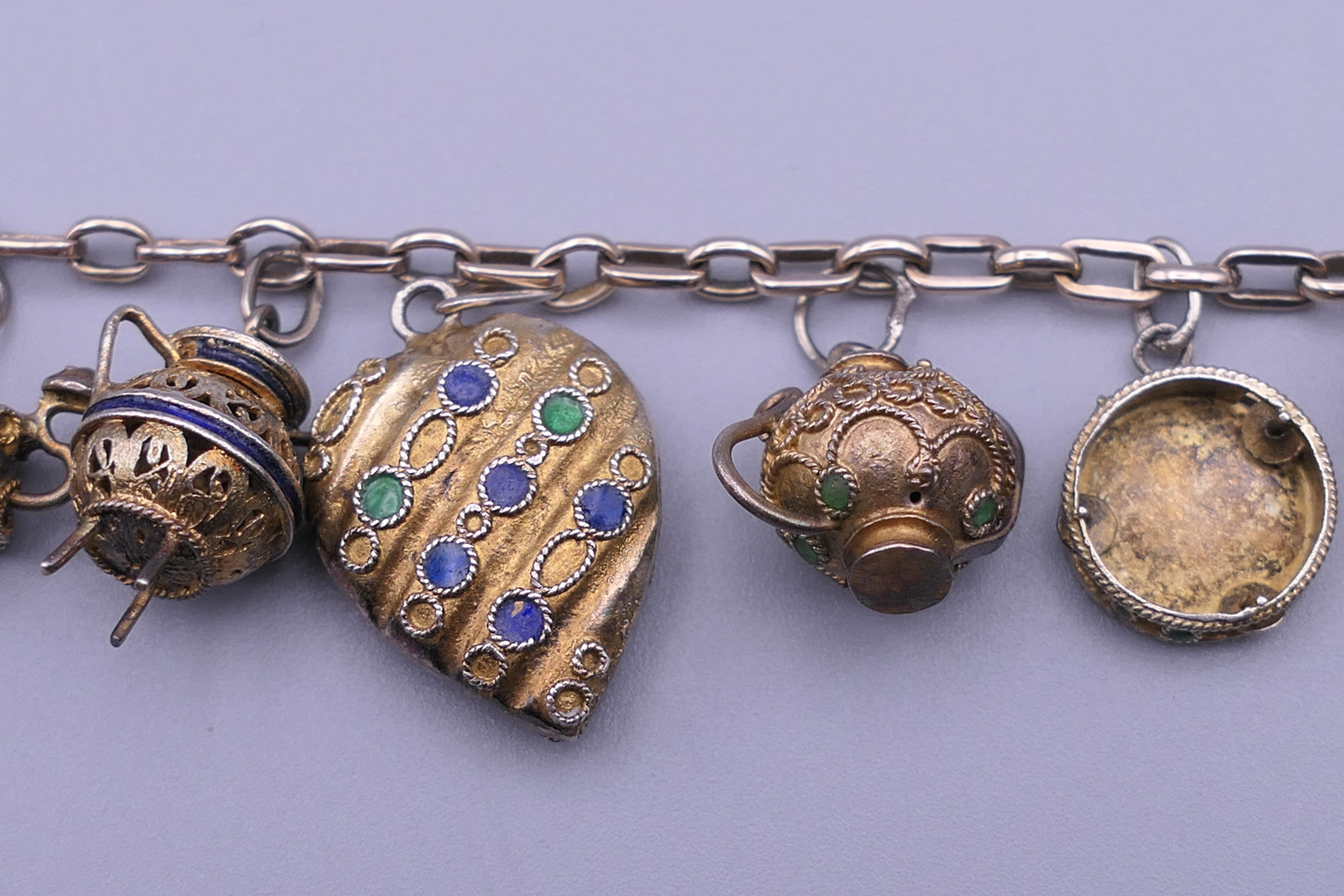 A unmarked gold bracelet with twelve silver gilt and enamelled charms. Approximately 18 cm long. - Image 4 of 6