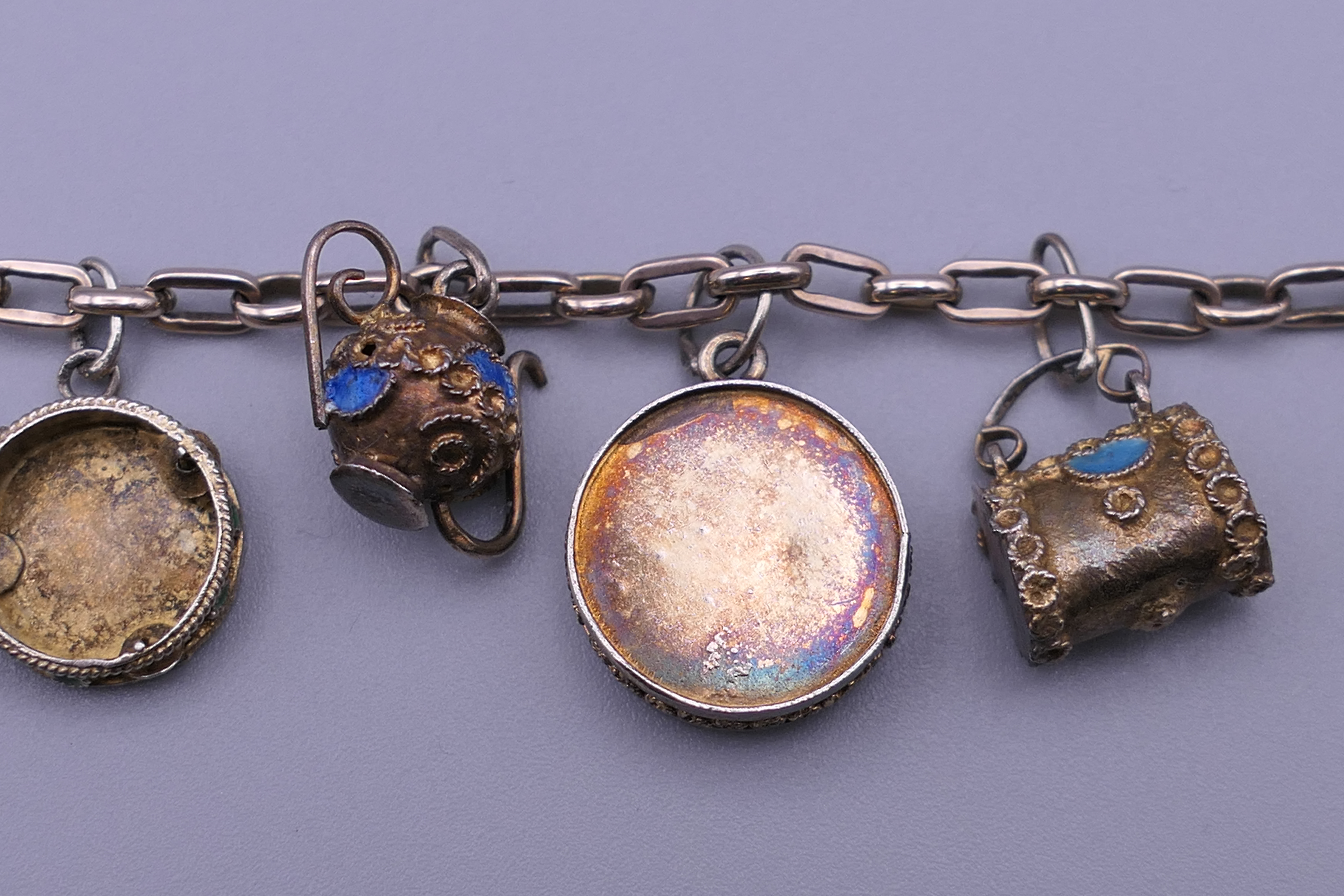 A unmarked gold bracelet with twelve silver gilt and enamelled charms. Approximately 18 cm long. - Image 5 of 6