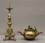 An antique double spouted brass cooking pot with handle for suspension and a brass pricket