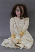 A porcelain headed doll. 70 cm tall.