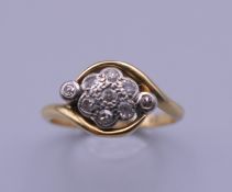 An 18 ct gold diamond cluster ring. Ring size N/O. 3.5 grammes total weight.